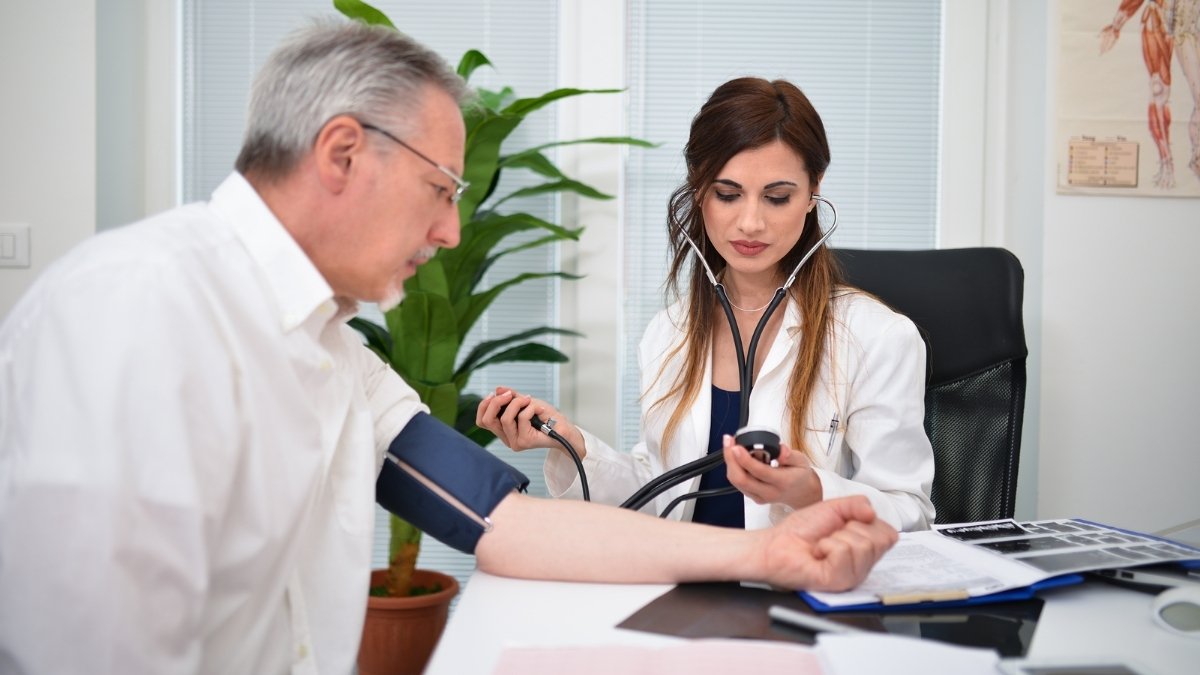A doctor measuring the blood pressure levels of a patient.