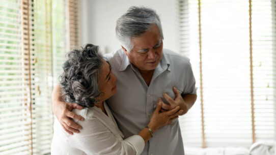 a woman holding a man undergoing heart attack